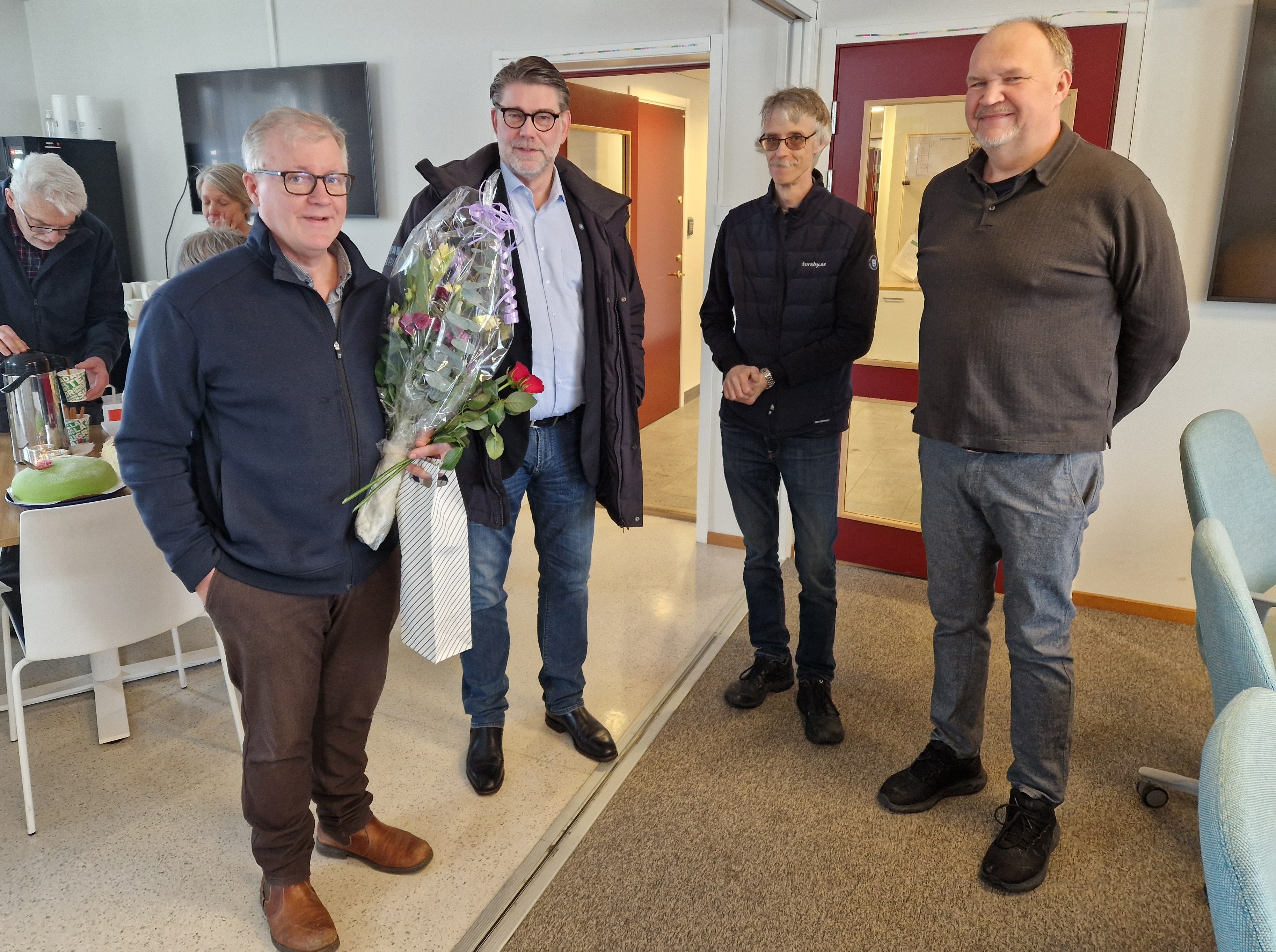 4 personer varav en med blomma i handen